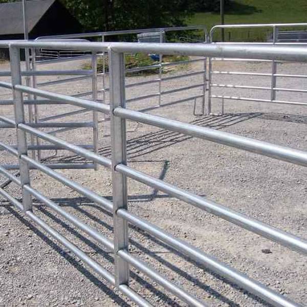 Several green steel corral panels are mounted together.