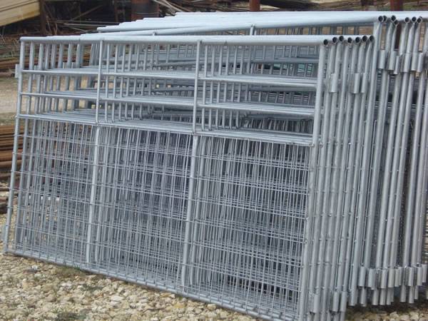 A steel corral panel with vertical bars and steel plates.